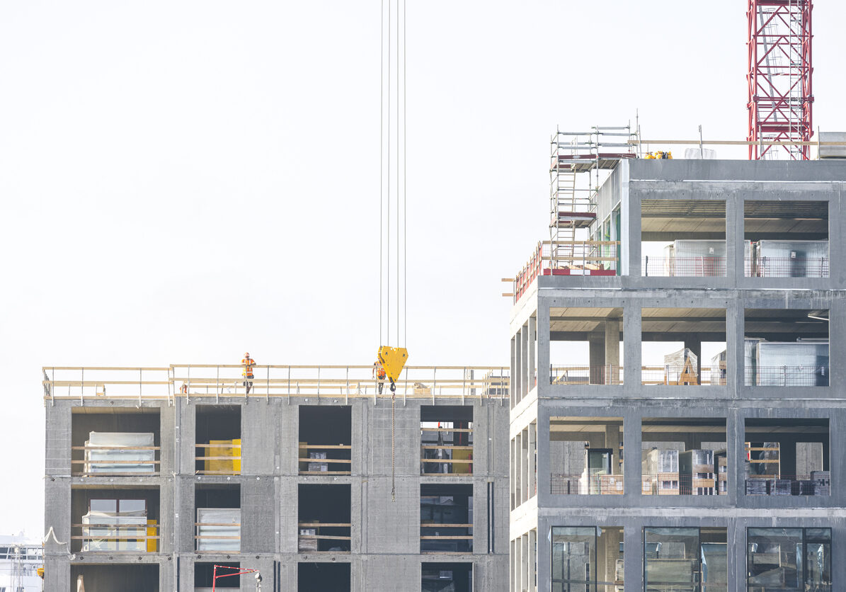 Construction site with cranes at Nordø in Copenhagen, Denmark. Workers in work with concrete. In this upscale neighbourhood you find luxury residential homes, offices and corporate buildings as well as shopping centers along the beautiful chanels.